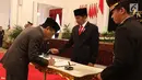 Khatib Aam PBNU Yahya Cholil Staquf menandatangani dokumen disaksikan Presiden Joko Widodo usai dilantik menjadi anggota Wantimpres menggantikan almarhum KH Hasyim Muzadi yang wafat. (liputan6.com/Angga Yuniar)