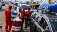 Petugas mengisi bahan bakar minyak (BBM) kendaraan di kios Pertamina tol fungsional (tol darurat) Brebes Timur-Gringsing, Tegal, Jawa Tengah, Jumat (30/6). PT Pertamina menjamin ketersedian BBM untuk arus balik aman. (Liputan6.com/Faizal Fanani)