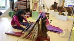 Seorang pengrajin membuat kain tenun pada Pameran Kerjasama Selatan-Selatan Triangular (KSST) di Jakarta Covention Center, Senin (19/4/2015). Pameran tersebut merupakan rangkaian dari acara KAA 2015. (Liputan6.com/Herman Zakharia)