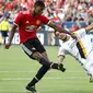 Pemain Manchester United, Marcus Rashford (kiri) melepaskan tembakan saat diadang pemain LA Galaxy, Hugo Arellano pada laga persahabatan di California, Sabtu (15/7/2017).  (AP/Jae C. Hong)