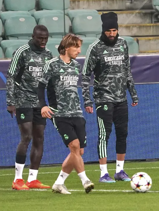<p>Pemain Real Madrid Luka Modric (tengah) dan Karim Benzema (kanan) menghadiri sesi latihan di Stadion Legia Warsawa, Warsawa, Polandia, 10 Oktober 2022. Real Madrid akan menghadapi Shakhtar Donetsk pada pertandingan sepak bola putaran pertama Liga Champions. (JANEK SKARZYNSKI/AFP)</p>
