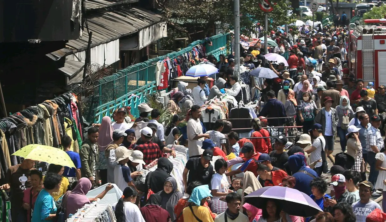Calon pembeli melihat barang dagangan di luar pasar senen, Jakarta, Sabtu (21/1). Pasca kebakaran tidak membuat para pedangang putus asa, sebagian dri mereka ada yang tetap berjualan meskipun harua di bahu jalan. (Liputan6.com/Angga Yuniar)