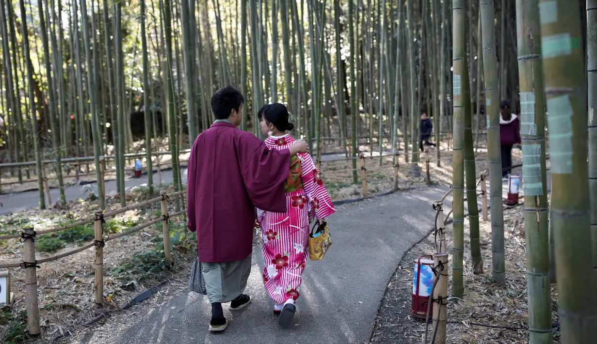 Wisatawan mengenakan kimono berjalan-jalan di Hutan Bambu Sagano di Arashiyama, Kyoto, Jepang pada 8 Desember 2018. Hutan seluas 16 km2 ini dinobatkan sebagai salah satu hutan terbaik di dunia. (Behrouz MEHRI / AFP)