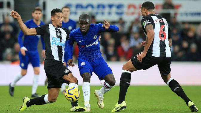 Pemain Chelsea N'Golo Kante (tengah) berusaha melewati pemain Newcastle United Joelinton (kiri) dan Jamaal Lascelles (kanan) pada pertandingan Liga Inggris di St James' Park, Newcastle, Inggris, Sabtu (18/1/2020). Newcastle United menang 1-0. (Lindsey Parnaby/AFP)