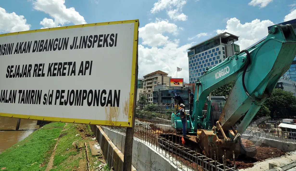 Pekerja mengerjakan pembangunan jalan inspeksi di Bantaran KBB kawasan Thamrin, Jakarta, Selasa (17/3/2015). Pembangunan jalan yang diproyeksikan untuk jalur alternatif bagi warga ini diperkirakan rampung pertengahan 2015. (Liputan6.com/Faizal Fanani)