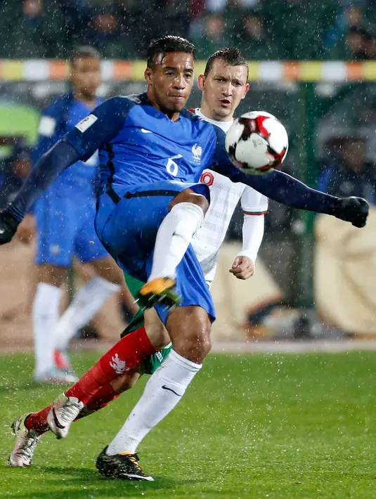 Pemain timnas Prancis, Corentin Tolisso berebut bola dengan pemain Bulgaria, Spas Delev pada laga Kualifikasi Piala Dunia 2018 zona Eropa Grup A di Stadion Vasil Levski, Sabtu (7/10). Les Bleus unggul 1-0 lewat gol lewat gol Blaise Matuidi. (AP Photo)