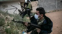 Seorang pasukan Pemerintah Kesepakatan Nasional (GNA) dukungan PBB yang mengenakan masker melepaskan tembakan ke arah pasukan Tentara Nasional Libya (LNA) yang berbasis di timur dalam pertempuran di garis depan Ain-Zara di Tripoli, Libya, (25/3/2020). (Xinhua/Amru Salahuddien)