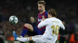 Gelandang Real Madrid, Luka Modric berebut bola dengan gelandang Barcelona, Frenkie de Jong pada pertandingan lanjutan La Liga Spanyol di stadion Camp Nou (18/12/2019). Barcelona bermain imbang 0-0 atas Real Madrid. (AP Photo/Joan Monfort)