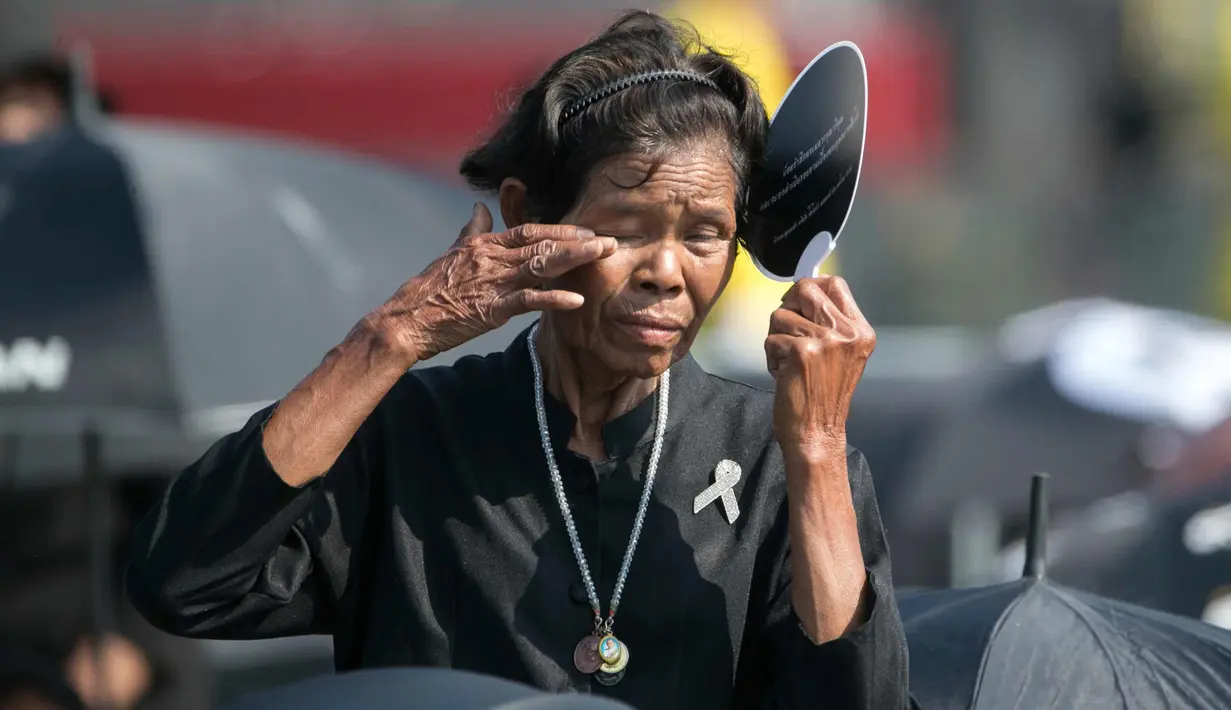 Seorang warga bersedih saat menghadiri upacara kremasi mendiang Raja Bhumibol Adulyadej di Bangkok, Thailand, Kamis, (26/10). Raja Bhumibol meninggal pada usia 88 tahun. (AP Photo/Wason Wanichakorn)