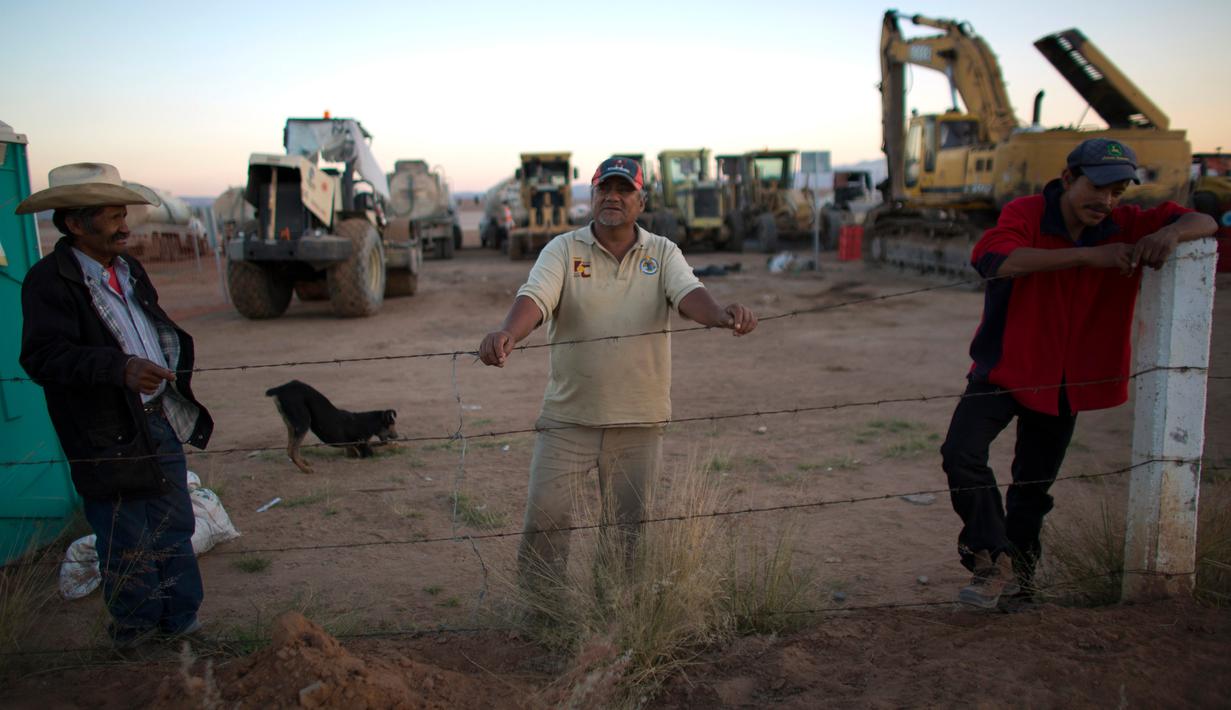 Sejumlah petugas berjaga di dekat alat berat yang tersisa di lokasi pembangunan pabrik Ford di di Villa de Reyes, San Luis Potosi, Meksiko, (4/1). (AP Photo/Rebecca Blackwell)