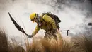 Seorang petugas pemadam kebakaran memadamkan kobaran api di Capilla del Monte, Cordoba, Argentina (15/10/2020). Selama berminggu-minggu, petugas pemadam kebakaran telah bekerja secara intensif memadamkan api di provinsi Córdoba, di Argentina tengah. (AP Photo/Mario Tizon)