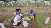 Warga berdoa di depan pusara keluarganya saat ziarah kubur di TPU Srengseng Sawah 2, Jagakarsa, Jakarta Selatan, Senin (17/5/2021). Hari ini seluruh TPU di wilayah DKI dibuka untuk umum dengan menerapkan protokol kesehatan seperti pembatasan pengunjung dan waktu berziarah. (merdeka.com/Arie Basuki)