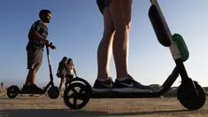 Pengendara menaiki skuter listrik  di sepanjang Venice Beach, Los Angeles, 13 Agustus 2018. Beberapa penduduk kota mengeluhkan skuter-e yang kontroversial karena membahayakan pejalan kaki dan terkadang menyumbat trotoar. (Mario Tama/Getty Images/AFP)