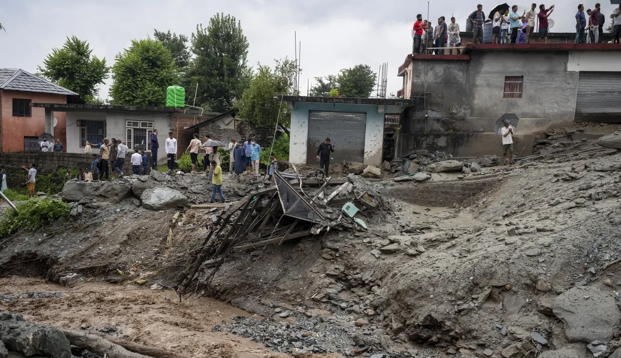 Orang-orang menyaksikan kerusakan yang disebabkan oleh tanah longsor setelah hujan deras di Khaniyara, dekat Dharmsala, India (2/9/2022). Tidak ada korban jiwa yang dilaporkan akibat musibah tersebut. (AP Photo/Ashwini Bhatia)