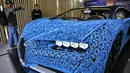 Pengunjung mengamati replika mobil Bugatti Chiron dari jutaan balok Lego Technic pada sebuah pameran di Taman Gorky Moskow, Selasa (23/7/2019). Mobil berwarna biru tersebut dibuat menggunakan lebih dari 1 juta blok Lego Technic dengan berat totalnya sekitar 1.500 kg. (Alexander NEMENOV/AFP)