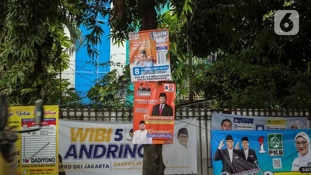 Sejumlah alat peraga kampanye (APK) terpasang pada pohon di kawasan Jakarta Selatan, Rabu (10/1/2024). Tak hanya bikin kumuh, maraknya pemasangan APK di pepohonan berpotensi merusak lingkungan hidup. Terlebih apabila pemasangan dilakukan menggunakan paku.