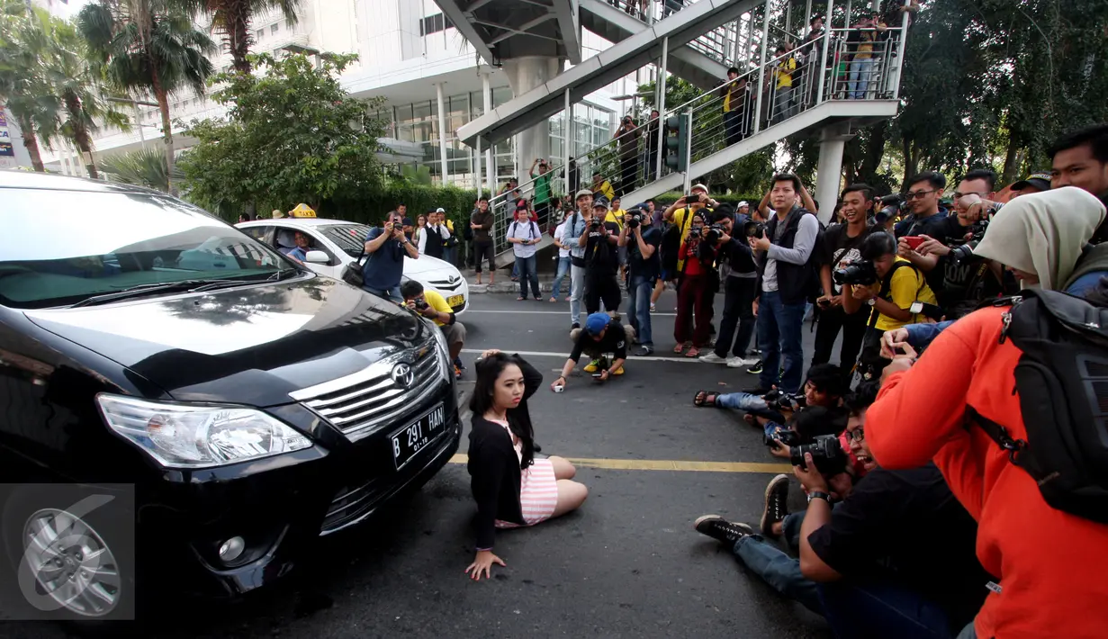 Model berpose di depan sebuah mobil saat fotograper melakukan pemotretan di Jalan MH Thamrin, Jakarta, Minggu (19/7/2015). Momen Jakarta sepi akibat banyak yang mudik, dimanfaatkan fotografer untuk memotret model. (Liputan6.com/Johan Tallo)