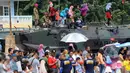 Warga menaiki tank saat Open Day Kolinlamil di Tanjung Priok, Jakarta, Minggu (24/7). Warga sekitar menyambut antusias acara HUT KOLINLAMIL 1 Juli 2016 yang Ke-55. (Liputan6.com/Helmi Afandi)