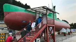 Pengunjung berada di dalam kapal selam Korut yang dipamerkan di "Taman Unifikasi" di Gangneung, Korea Selatan, (18/2). Para awak kapal meninggalkan kapal tersebut dan menuju ke pegunungan kasar dan diburu pemerintah Korea Selatan. (AP Photo/Johnson Lai)