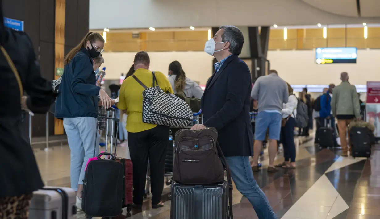 Orang-orang berbaris untuk dites Covid-19 di bandara OR Tambo di Johannesburg, Jumat (26/11/2021). Sejumlah negara menghentikan perjalanan udara dari Afrika Selatan terkait kemunculan varian baru COVID-19 yang berpotensi lebih menular yang telah terdeteksi di Afrika Selatan. (AP/Jerome Delay)