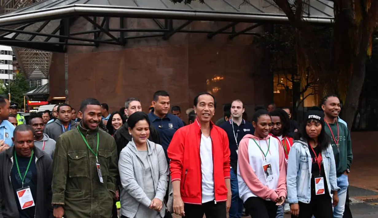 Presiden Joko Widodo dan Ibu Negara Iriana Joko Widodo berjalan kaki sambil berbincang bersama pelajar dan mahasiswa Indonesia di sekitar Water Front di Selandia Baru (19/3). (Liputan6.com/Pool/Biro Pers Setpres)