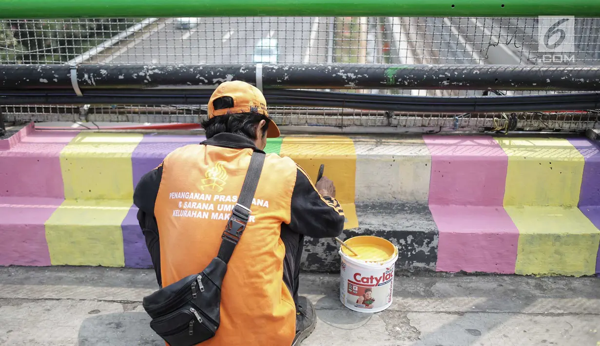 Pasukan oranye atau PPSU menyelesaikan pengecatan warna-warni jembatan layang di kampung Makasar, Jakarta, Kamis (26/7).  Pengecatan dilakukan guna mempercantik dan menyambut Asian Games 2018 pada bulan Agustus mendatang.  (Liputan6.com/Faizal Fanani)