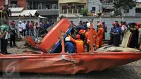 Petugas melakukan evakuasi kepada Metromini yang tertabrak kereta di perlintasan Angke, Tambora, Jakarta, Minggu (6/12/2015). Sebanyak 13 orang dilaporkan tewas. (Liputan6.com/Gempur M Surya)  