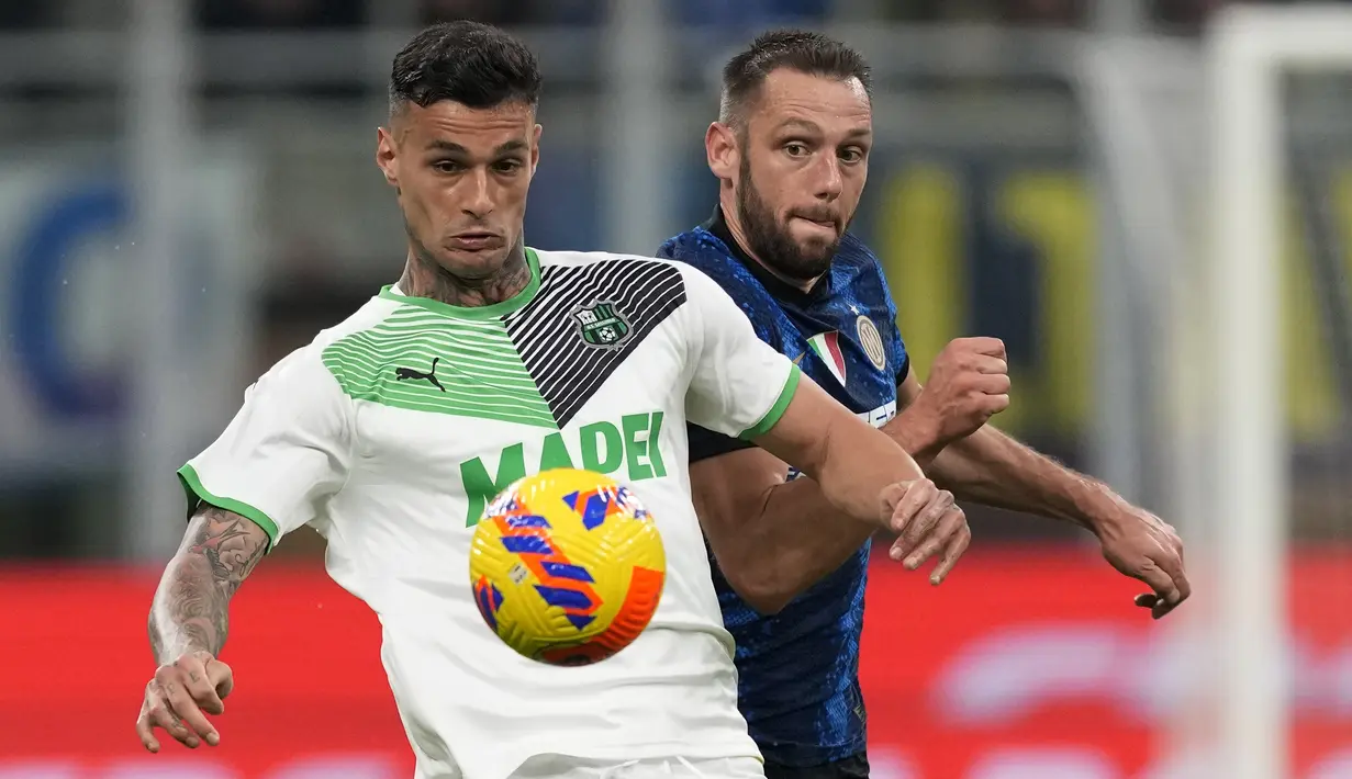 Penyerang Sassuolo, Gianluca Scamacca berebut bola dengan bek Inter Milan, Stefan de Vrij selama pertandingan lanjutan Liga Serie A Italia di Stadion San Siro, di Milan, Italia, Senin (21/2/2022). Inter Milan kalah atas Sassuolo 0-2. (AP Photo/Antonio Calanni)