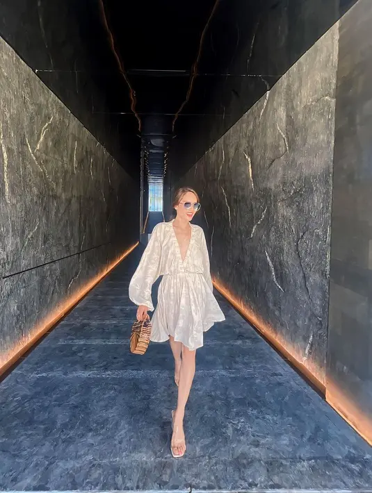 Ia mengenakan mini puffy sleeves dress berwarna creme yang dipadukan dengan clear heels. [@claurakiehl]