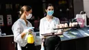 Dua orang staf membagikan sampel kue gratis kepada pelanggan di sebuah pusat perbelanjaan di Berlin, Jerman (9/5/2020). (Xinhua/Binh Truong)