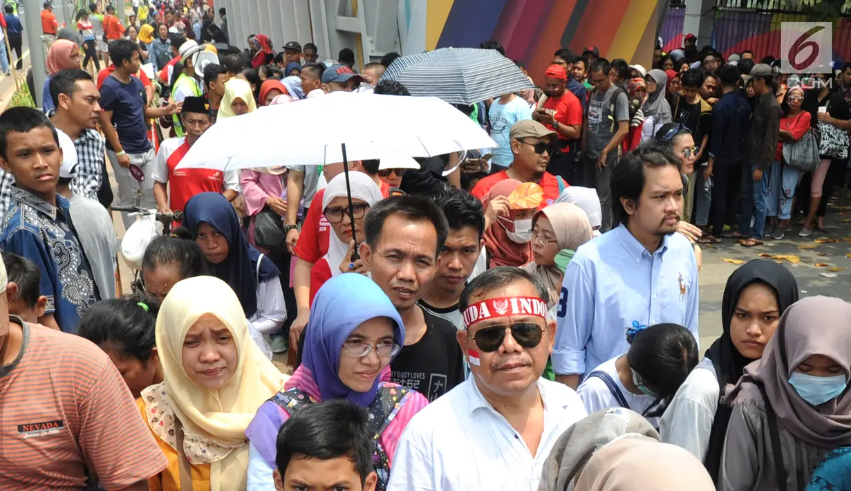 Calon penonton rela antre di sepanjang pendestrian Senayan untuk mengikuti Closing Ceremony Asian Games 2018, di Stadion GBK, Jakarta, Minggu (2/9).Sejumlah artis dalam dan luar negeri ikut meramaikan Closing Ceremony. (merdeka.com/Arie Basuki)