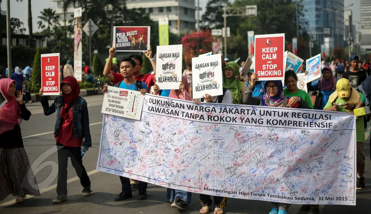 Aktivis membentangkan spanduk berisi tanda tangan warga saat peringatan Hari Tanpa Tembakau di Bundaran HI, Jakarta, Minggu (31/5). Hari Tanpa Tembakau Sedunia diperingati di seluruh dunia setiap tahun pada tanggal 31 Mei. (Liputan6.com/Faizal Fanani)