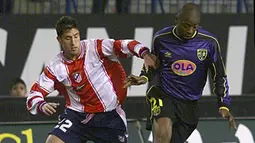 Pemain Atletico Madrid berusaha merebut pemain Lens, Nouma (kanan) pada laga kualifikasi pertandingan UEFA di Madrid 2 Maret 2000. Atletico Madrid selalu mengusung jersey strip vertikal merah dan putih. Pada musim 1999/2000, jersey mereka terlihat polos tanpa logo sponsor di bagian tengahnya. (AFP/Denis Charlet)