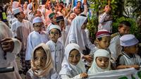 Bertepatan dengan malam Tahun Baru Islam 1 Muharram 1447 Hijriah, masyarakat kota Surabaya, Jawa Timur melakukan tradisi pawai obor di salah satu permukiman pada Kamis 26 Juni 2025 malam. (Juni KRISWANTO/AFP)