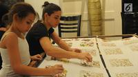 Dua wanita Amerika Latin saat membuat batik dalam kelas bersama Rumah Batik Palbat di Tugu Kunstring Paleis, Jakarta, Kamis (22/3). Kegiatan membuat batik tulis dan batik cap ini hasilnya akan didonasikan untuk amal. (Merdeka.com/Arie Basuki)
