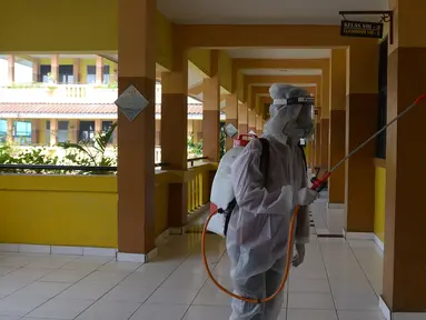 Petugas PMI menyemprotkan cairan disinfektan di Lingkungan SMP Negeri 139 Jakarta, Selasa (9/6/2020). Penyemprotan untuk mencegah penyebaran virus Corona di lingkungan sekolah itu sebagai persiapan memasuki tahun ajaran baru 2020/2021. (merdeka.com/Imam Buhori)