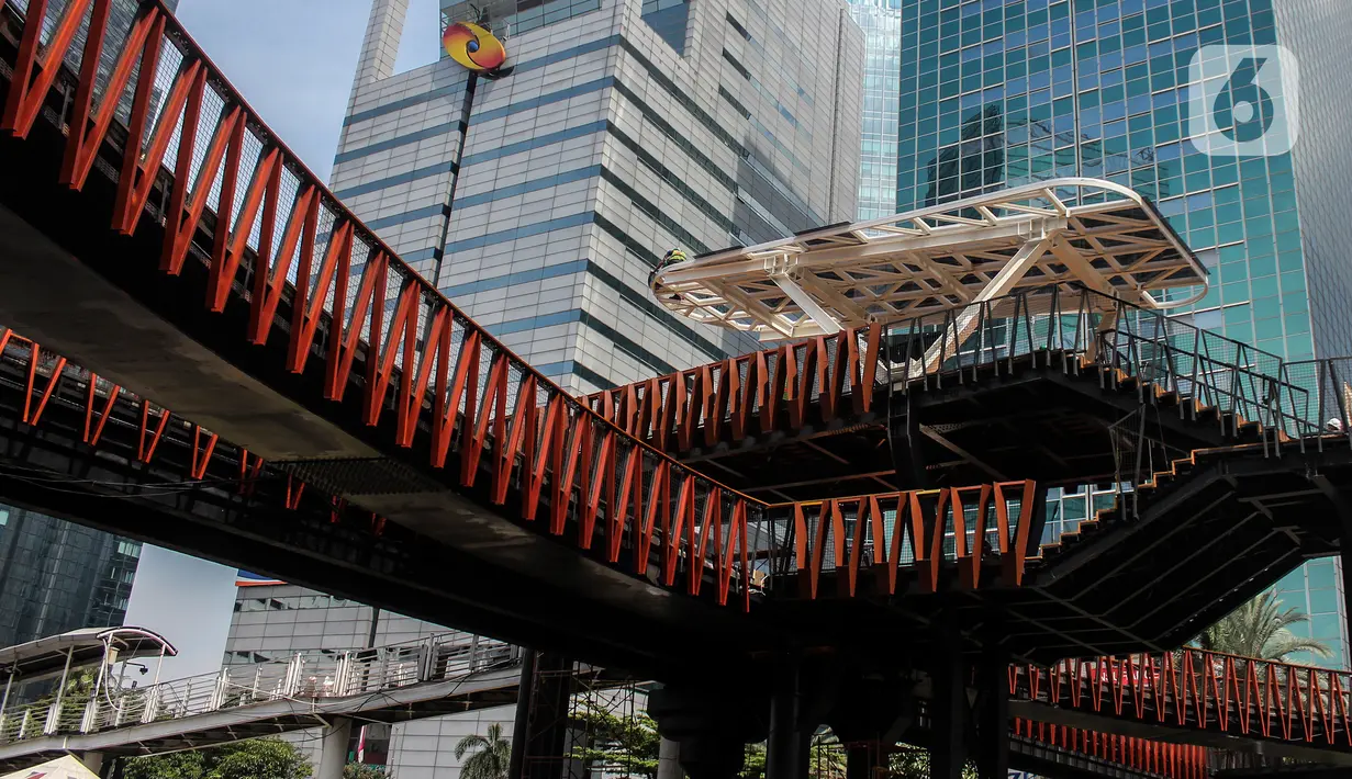 Aktivitas pengerjaan revitalisasi Jembatan Penyeberangan Orang (JPO) di Jalan Sudirman, Jakarta, Minggu (19/12/2021). JPO yang juga dilengkapi Anjungan Pandang Jakarta dan terintegrasi halte TransJakarta ini telah mencapai 95 persen dan akan dapat diakses pada akhir 2021. (Liputan6.com/JohanTallo)