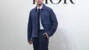 Ia memadukan kemeja sky blue dengan Dior Icons Workwear Jacket Navy Rp110jutaan. Dilengkapi dengan celana senada dan sneakers putih