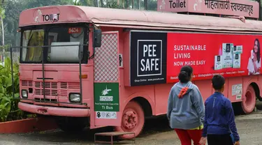 Foto pada 9 Februari 2020 menunjukkan orang-orang berjalan melewati toilet keliling di sebuah bus di taman umum di Pune, India. Proyek Ti Toilet, sebuah bus yang diubah menjadi toilet dan diluncurkan pada tahun 2016, adalah gagasan Ulka Sadalkar dan Rajeev Kheer. (Indranil MUKHERJEE/AFP)