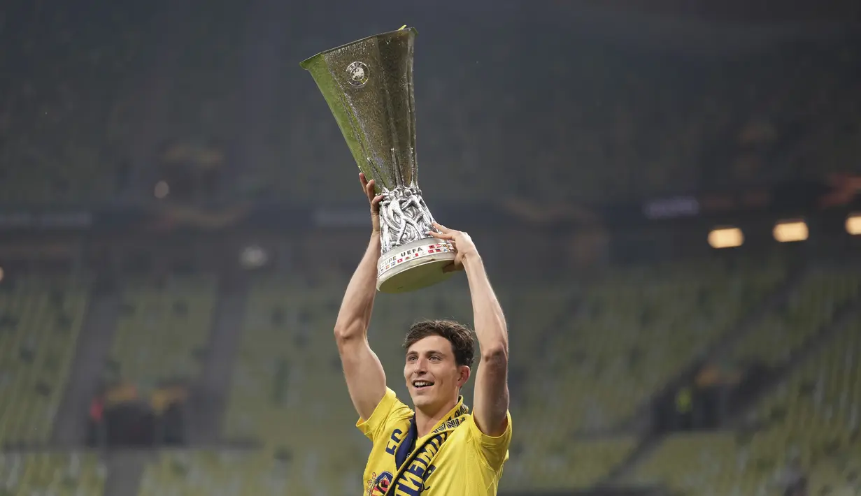 Bek Villareal, Pau Torres mengangkat trofi saat merayakan timnya memenangkan pertandingan melawan Manchester United pada final Piala Europa di Gdansk, Polandia, Kamis (27/5/2021).  Villareal menang 11-10 setelah memaksa MU bermain imbang 1-1 hingga tambahan waktu. (AP Photo/Michael Sohn, Pool)