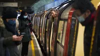 Para penumpang naik kereta Bawah Tanah Jubilee Line di Stasiun Canning Town selama jam sibuk di London, Inggris, 12 Januari 2021. Inggris sedang menerapkan lockdown nasional ketiga untuk mengekang penyebaran virus corona COVID-19. (Victoria Jones/PA via AP)