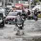 Sejumlah kendaraan terjebak kemacetan akibat banjir yang menggenangi Jalan Jatinegara Barat, Jakarta, Senin (8/2/2021). Banjir yang menggenangi Jalan Jatinegara Barat terjadi akibat luapan Kali Ciliwung yang dipicu hujan deras di Jakarta dan Bogor sejak dini hari tadi. (merdeka.com/Iqbal S. Nugroho)