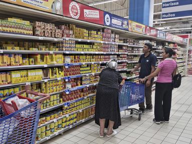 Orang-orang berbelanja di sebuah supermarket, di Tunis, Tunisia, pada 10 Oktober 2022. Gula, minyak sayur, beras, bahkan air kemasan – warga Tunisia telah menderita kekurangan beberapa bahan pokok dalam beberapa pekan terakhir. Dan biaya melonjak pada produk yang masih tersedia. (AP Photo/Hassene Dridi)
