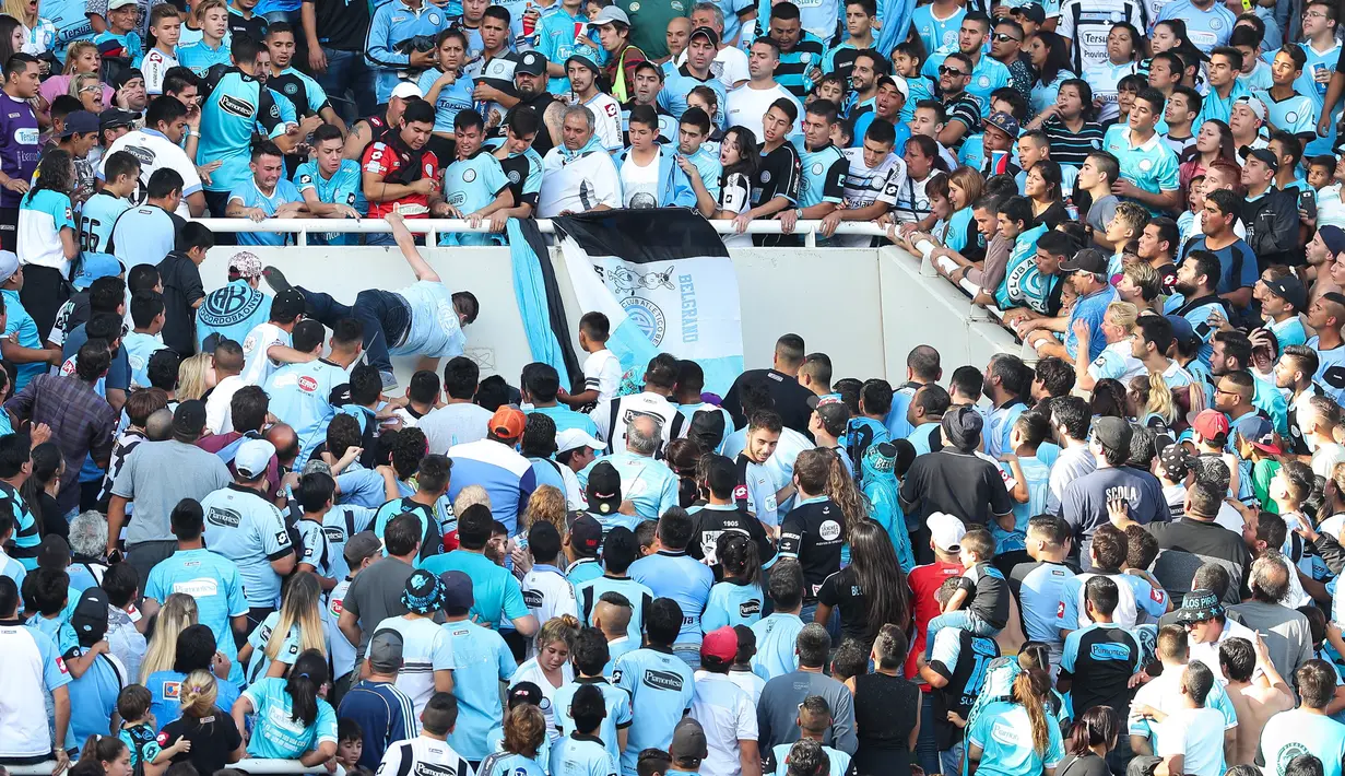 Emanuel Balbo didorong dari tribun oleh penonton lain saat menyaksikan pertandingan antara tim Belgrano dengan Talleres di Stadion Belgrano, Argentina, 15 April 2017. Sampai saat ini empat pelaku sudah diamankan pihak kepolisian. (NICOLAS AGUILERA/AFP)