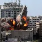 Bola api meletus dari gedung yang menampung berbagai media internasional, termasuk The Associated Press, setelah serangan udara Israel di Kota Gaza, Sabtu (15/5/2021). Gedung tersebut juga menampung Al Jazeera dan sejumlah kantor serta apartemen. (Mahmud Hams /Pool Photo via AP)
