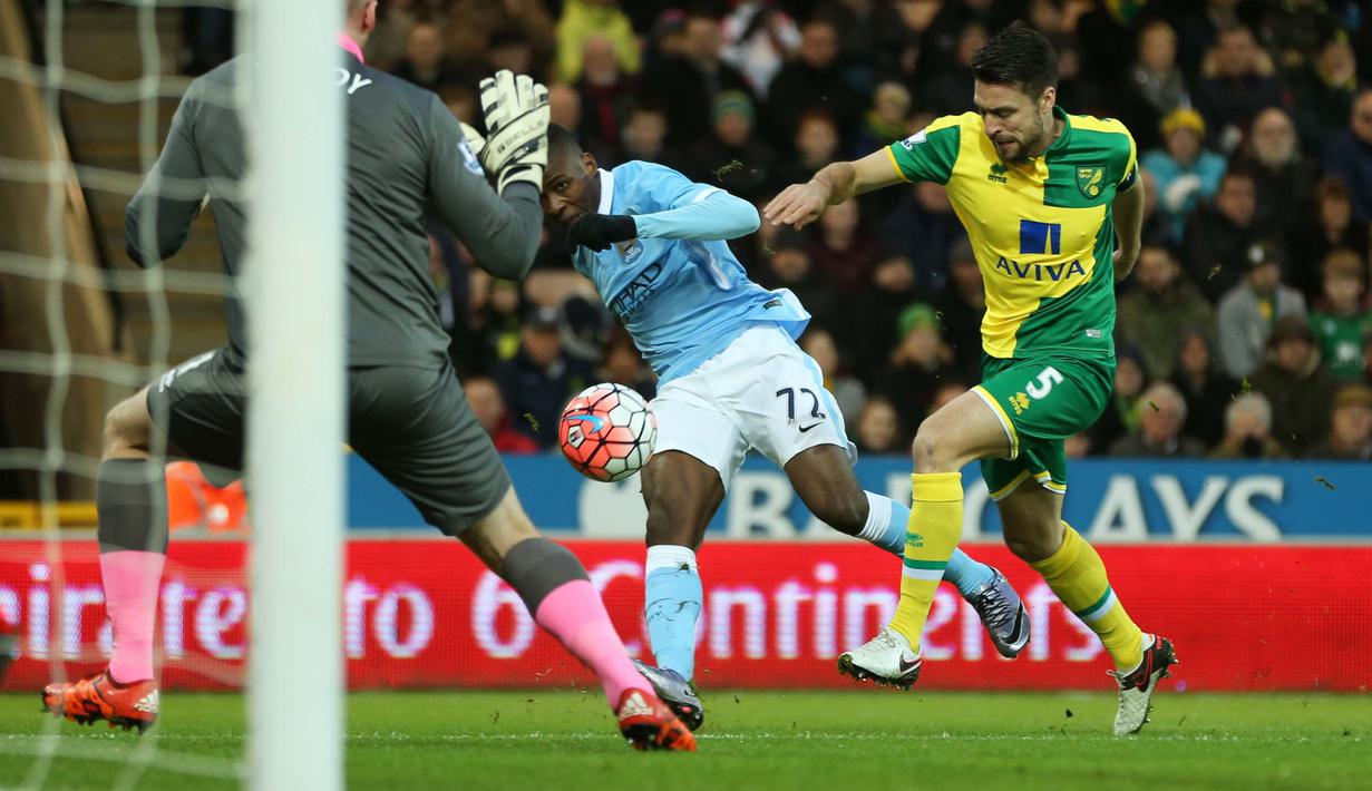 Pemain Manchester City, Kelechi Iheanacho melakukan tembakan kearah gawang saat dihadang pemain Norwich City, Russell Martin pada laga Babak ketiga Piala FA di Stadion Carrow Road, Norwich, Sabtu (9/1/2016). (Reuters/Alex Morton)