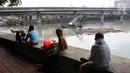 Warga menyaksikan proses pengerukan Waduk Grogol, Jakarta, Senin (9/4). Pengerukan dilakukan untuk mengatasi permasalahan banjir di Ibu Kota. (Liputan6.com/Arya Manggala)