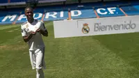 Pemain baru Real Madrid, Vinicius Jr menunjukkan kostumnya saat diperkenalkan di Stadion Santiago Bernabeu, Madrid, Spanyol, Jumat (20/7). (AP Photo/Francisco Seco)