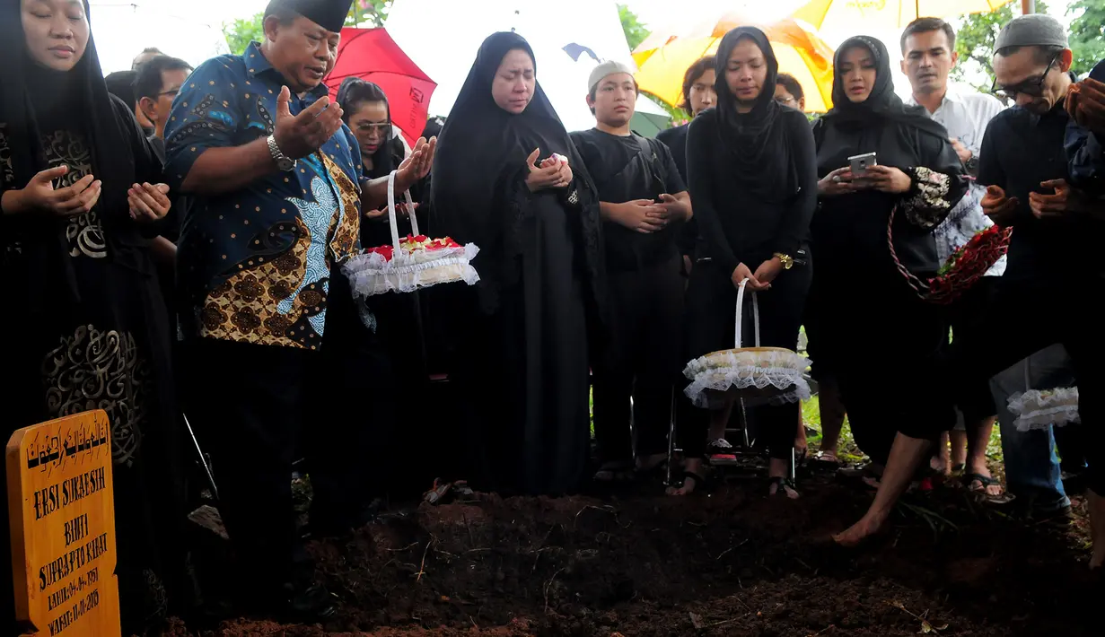 Melly Goeslaw dan keluarga mendoakan ibunya yang baru saja dimakamkan, TPU Tanah Kusir, Bintaro, Senin (12/1/2015). (Liputan6.com/Faisal R Syam)