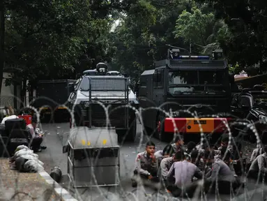 Petugas berjaga dibalik kawat berduri yang dipasang didepan Kedutaan Besar Myanmar, Jakarta, Rabu (6/9).  Jelang aksi yang rencananya akan dihadiri puluhan ribu orang, pihak kepolisian berjaga di sekitar Kedubes Myanmar. (Liputan6.com/Faizal Fanani)